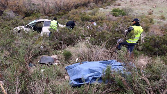 El cadáver de Namuncurá yace en el barranco y su Ford Fiesta, destruido al fondo. Personal de Bomberos y la Policía rescatan el cuerpo. El auto fue atravesado por un tronco.