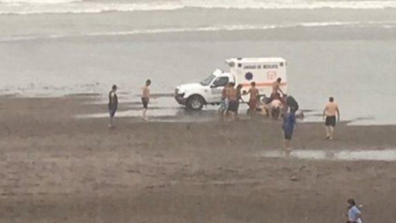 Una ambulancia y los guardavidas en el momento de asistir a un bañista.