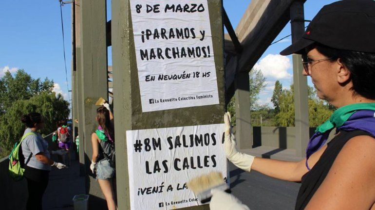 Integrantes de La Revuelta pegaron carteles para convocar al paro del 8M.