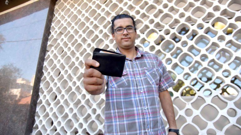 Pablo Serrano muestra la billetera que se encontró en la plaza Roca.