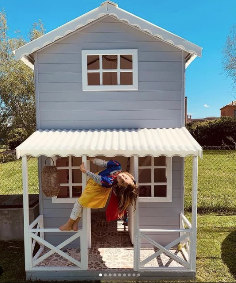 La casa infantil de madera gris es el lugar de juego preferido de las hijas de Mery.