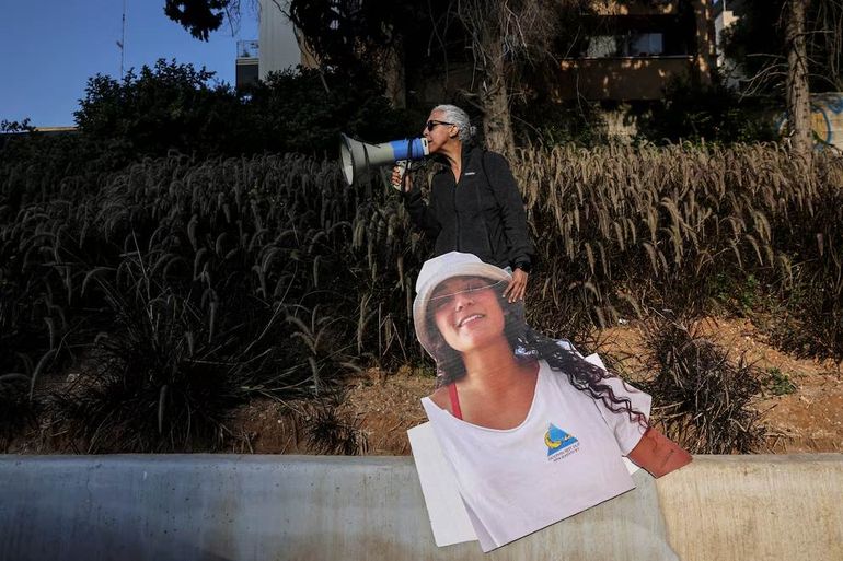 Una mujer sostiene una fotografía recortada de la rehén Emily Damari. Una mujer sostiene una fotografía recortada de la rehén Emily Damari.