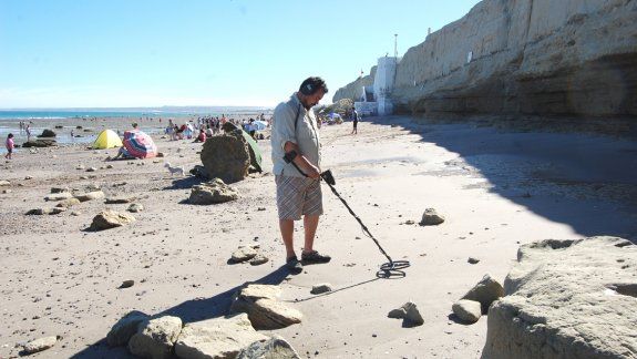 Un turista busca tesoros con un detector de metales