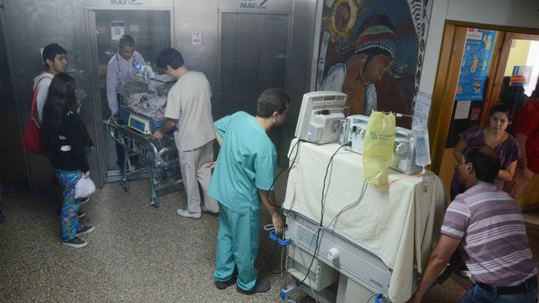 Médicos y enfermeros trasladan a dos bebés prematuros para ser reubicados en otro sector del hospital.