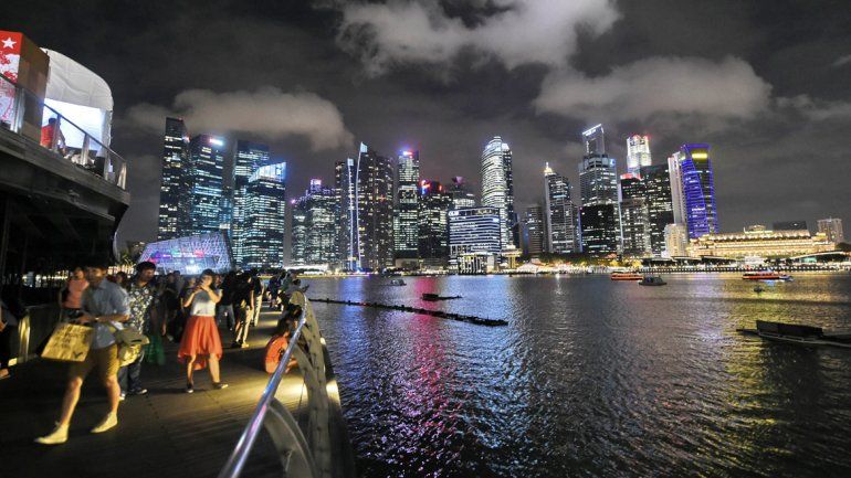 Turistas durante un paseo nocturno por la carísima ciudad de Singapur.