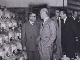 Visita del gobernador Castello en Cipolletti, año 1960. Visita a la Bodega Flor del Prado. En la imagen se ven las damajuanas de vino. Gentileza: Archivo Cabus Trenes