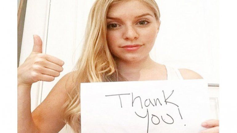 Kaitlyn con su cartel de agradecimiento a su héroe -por ahora- anónimo.