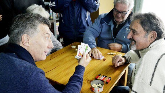 Con el as de basto en la mano, ayer, Mauricio Macri al visitar un centro de jubilados en Boulogne.