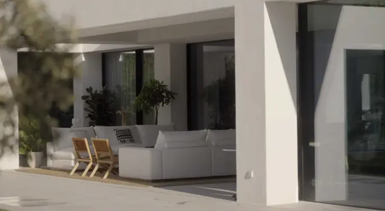 La galería dela mansión, con un impecable living de exterior en blanco.