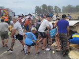 Mientras los socorristas trabajaban en sacar al chofer del camión, vecinos se llevaban la carga. Foto: La Opinión de Pergamino.