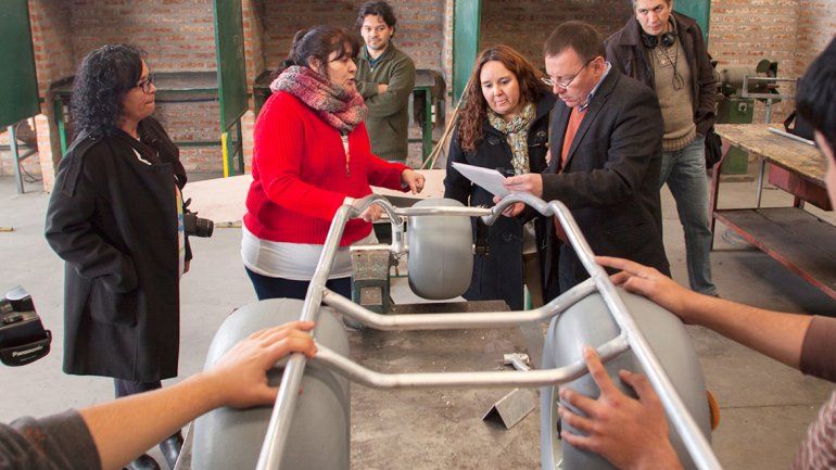 Méndez y los integrantes de la comunidad educativa junto a la silla.