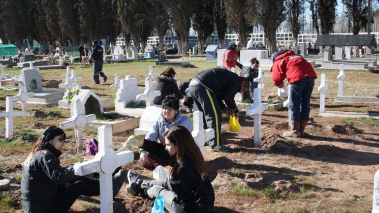 Empleados municipales pintan las cruces del cementerio.