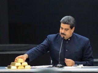 Foto de archivo del presidente de Venezuela, Nicolas Maduro, tocando una pila de lingotes de oro durante una rueda de prensaa en el Palacio de Miraflores en CaracasMar 22, 2018. REUTERS/Marco Bello