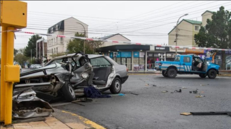 El Volkswagen de Rodrigo "Cokito" Oyarzo destruido y, al fondo, la camioneta de Tr&aacute;nsito, el 5 de marzo de 2023 en la esquina de avenida San Mart&iacute;n y Mariano Moreno, en R&iacute;o Gallegos.