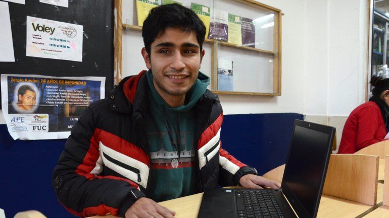 Carlos Tapia en el aula de la facultad con su vieja máquina que escribe en braille y con su nueva notebook. 
