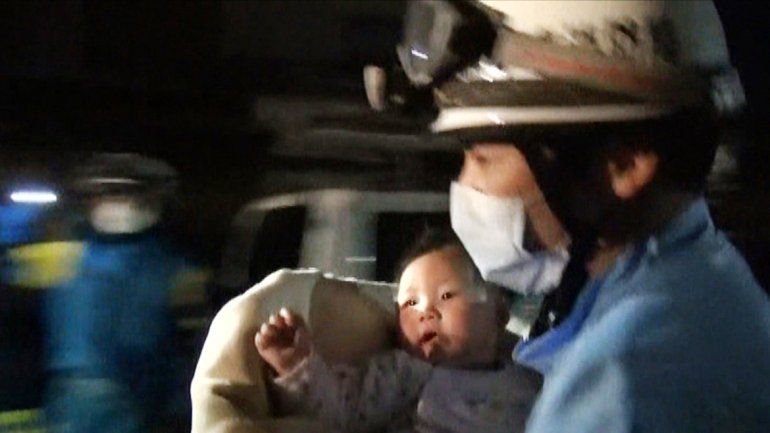 Un rescatista con un bebé en brazos en Kumamoto.