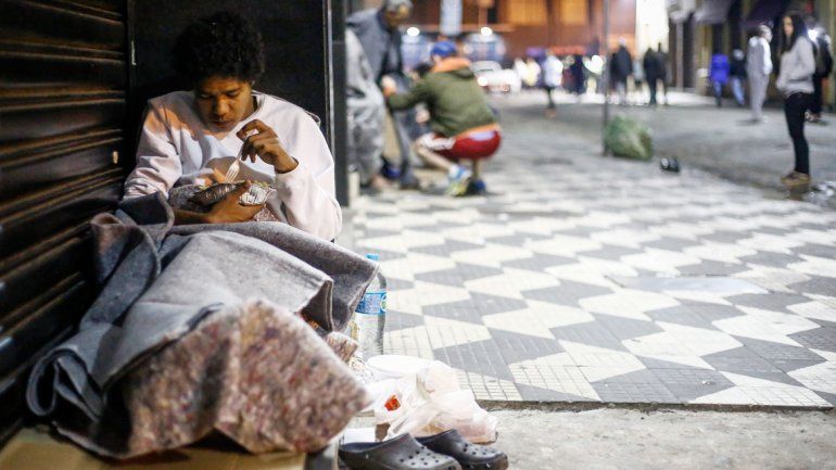 Una mujer comiendo en una calle céntrica de San Pablo