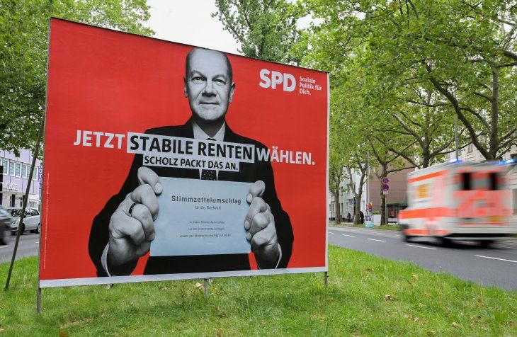 FOTO DE ARCHIVO: Un coche pasa cerca de un cartel electoral que muestra a Olaf Scholz, ministro de Finanzas alemán y principal candidato del Partido Socialdemócrata de Alemania (SPD), que sostiene una