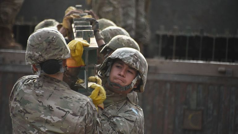 Más de 10 soldados levantan parte de la estructura del puente Bailey, que se colocará en el brazo del río Neuquén. Más de 10 soldados levantan parte de la estructura del puente Bailey, que se colocará en el brazo del río Neuquén.