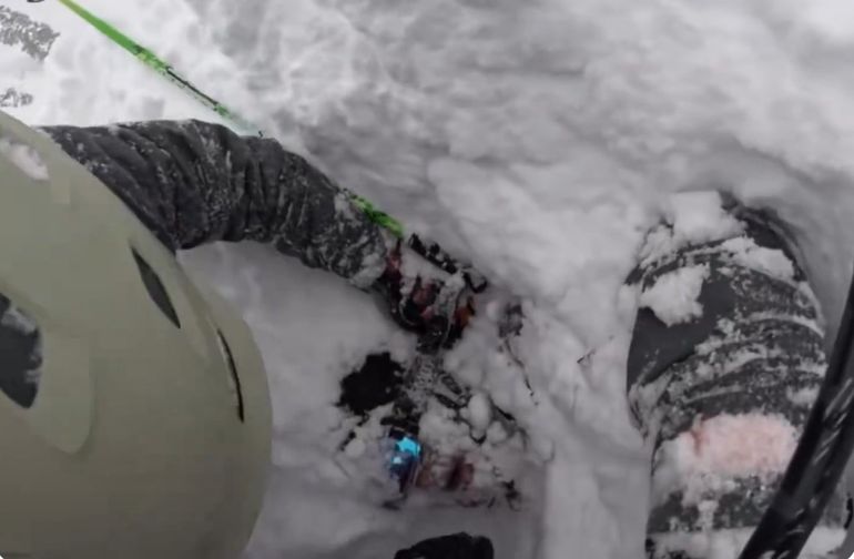 El esquiador sepultado asoma la cara después de que dos hombres removieran la nieve que estaba encima de él. El esquiador sepultado asoma la cara después de que dos hombres removieran la nieve que estaba encima de él.