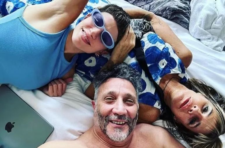 El cantante con su novia y su ex en la cama.