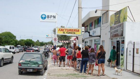 Largas colas frente a una de las sucursales del BPN. La gente se decepciona y se enoja con los comerciantes.