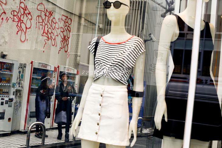 Imagen de archivo de personas junto al escaparate de una boutique de moda en un distrito comercial en Tokio