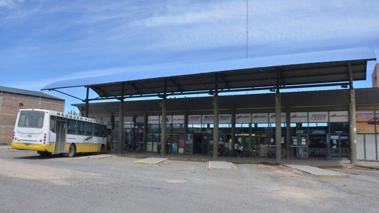 La gente espera el micro al rayo del sol en Plottier