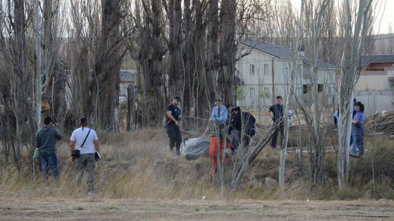 Personal de Bomberos de Neuquén retirando el cadáver del canal de riego.