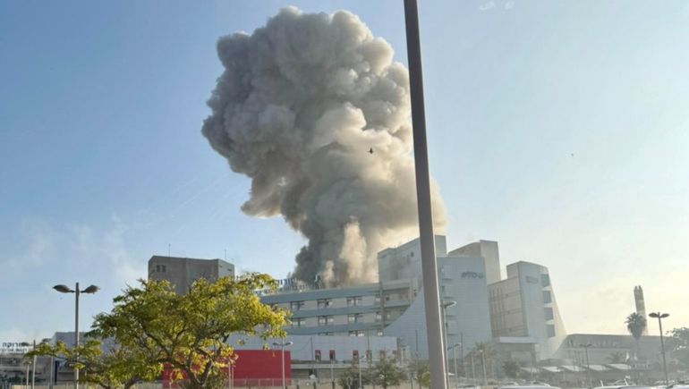 Una columna de humo se eleva por encima del hospital del sur de Israel impactado por el bombardeo de Irán.