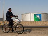 FOTO DE ARCHIVO. Un empleado pasa en bicicleta frente a tanques de petróleo de la compañia saudita ARAMCO en Abqaiq, Arabia Saudita. REUTERS/Maxim Shemetov