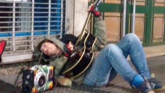 El ex Intoxicados tocando en el piso sobre la calle Corrientes, luego de tomar la guitarra de un músico callejero.
