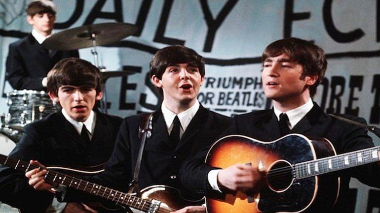Lennon junto a la Gibson J-160E que le robaron en 1963.