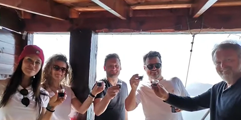 Baldini brindando con su nuevo amor (en el medio, con remera negra) y sus compañeros de viaje.