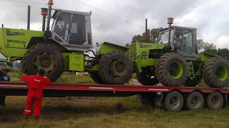 Los tractores y la pulverizadora al ser cargados para viajar a Neuquén.