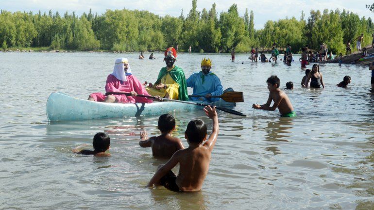 Llegaron en bote y repartieron golosinas. Fueron sensación entre los niños que se bañaban en el Limay.