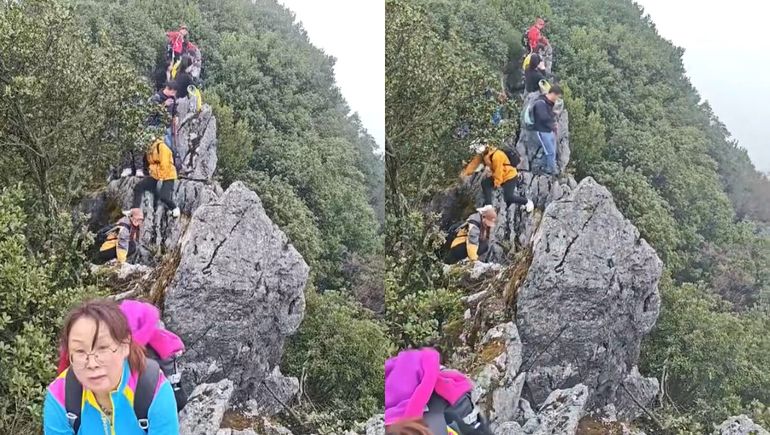 Al menos una decena de personas se encontraban junto al turista, agarrados firmemente de las piedras para no caerse. Al menos una decena de personas se encontraban junto al turista, agarrados firmemente de las piedras para no caerse.