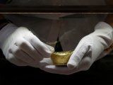 Asistente de ventas saca un adorno de oro para un cliente en la joyería Caibai, Pekín, China, 6 agosto 2019.REUTERS/Jason Lee/Archivos