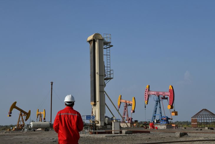 FOTO DE ARCHIVO. Trabajadores cerca de bombas de extracci&oacute;n en un campo petrol&iacute;fero de China National Petroleum Corp (CNPC) en Bayingol, Regi&oacute;n Aut&oacute;noma Uigur de Xinjiang, China.