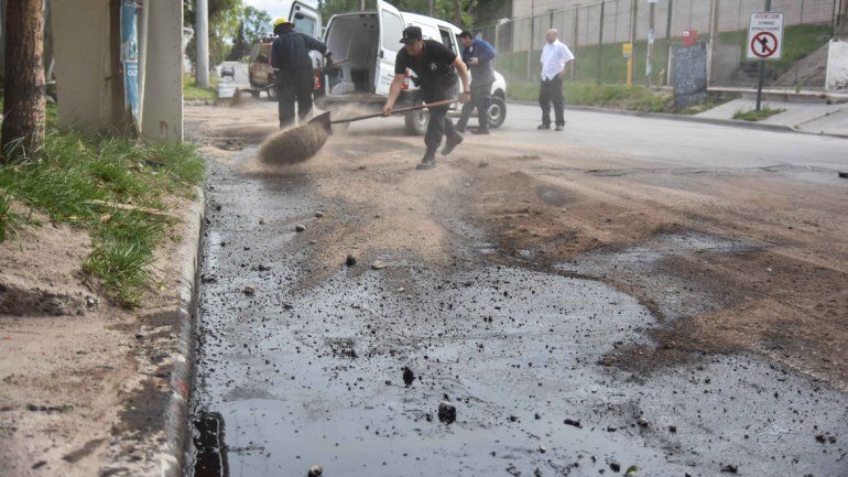 Operarios remediando el derrame que provocó una concesionaria de autos en calle Obrero Argentino.
