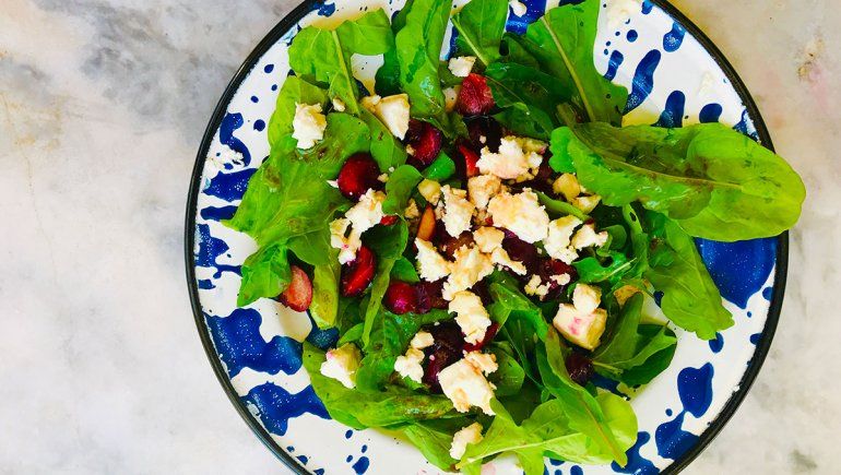 Una ensalada fresca con rúcula, queso y cerezas