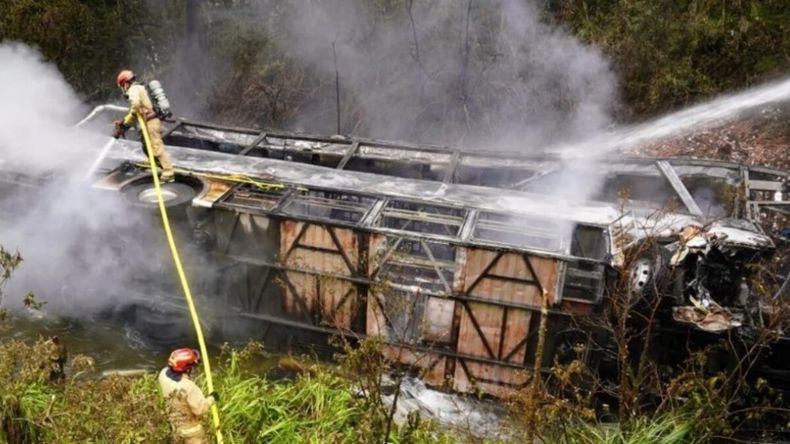 Bomberos trabajan entre humo y restos del colectivo incendiado tras el accidente en una zona de difícil acceso en Ecuador. | LM Neuquen Bomberos trabajan entre humo y restos del colectivo incendiado tras el accidente en una zona de difícil acceso en Ecuador.