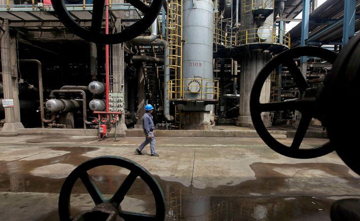 FOTO DE ARCHIVO: Un trabajador camina junto a tuberías de petróleo en una refinería en Wuhan, provincia de Hubei, China. 23 de marzo, 2012. REUTERS/Stringer/Archivo