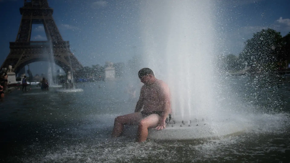 Un niño se refresca en una fuente, en proximidades de la Torre Eiffel en París, esta semana.