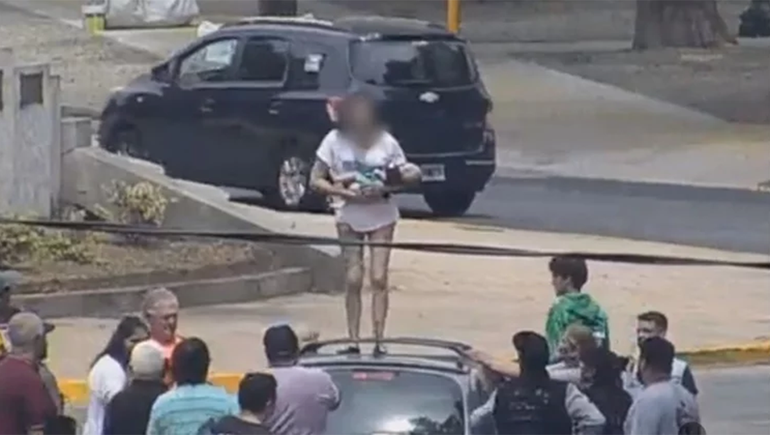 Una mujer se subió al techo de un auto y quiso tirar a su bebé