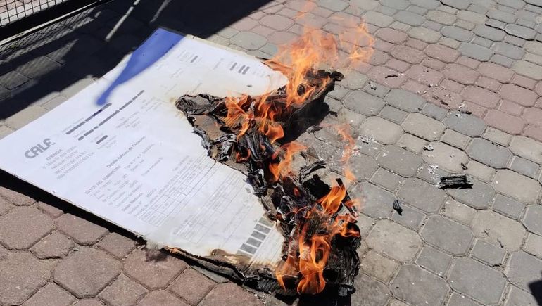 Los vecinos queman una factura de CALF frente al Concejo Deliberante. Foto: Prensa MST. Los vecinos queman una factura de CALF frente al Concejo Deliberante. Foto: Prensa MST.