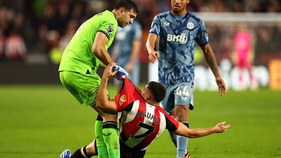 El momento en el que Dibu Martínez intenta levantar al francés Maupay.&nbsp;