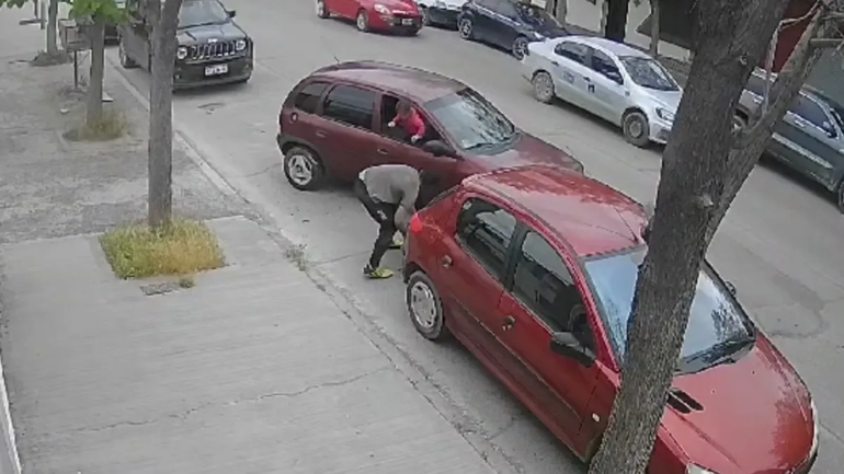 Impactante imagen. La nena asomada contemplando el robo de su allegado. Foto captura de video.