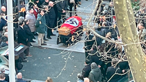 ponen una bandera nazi sobre un ataud durante un funeral