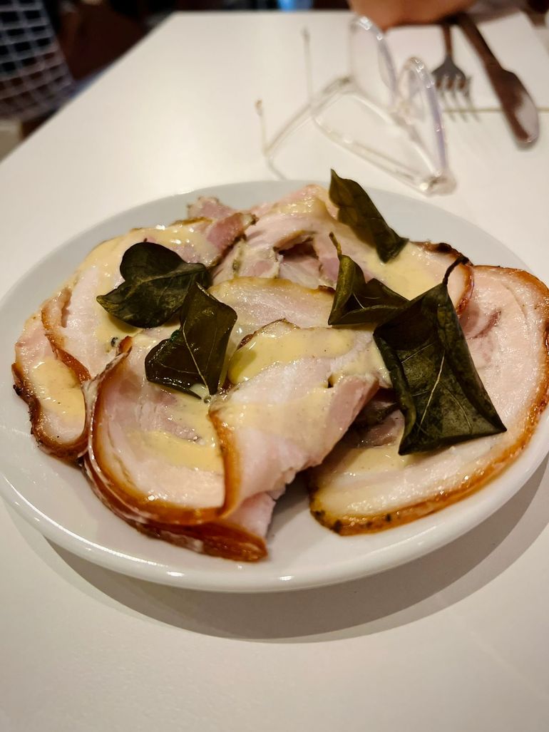 Porchetta casera en alianza con productores regionales. Hojas de alcaparras fritas.Maravilla.